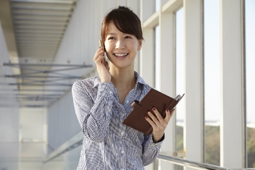 スマートフォンを持つ女性のイメージ